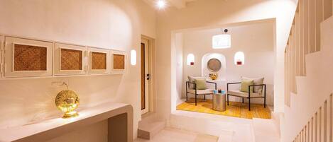 A modern interior with a white console table, a decorative golden object, and a seating area with a round table and chairs.