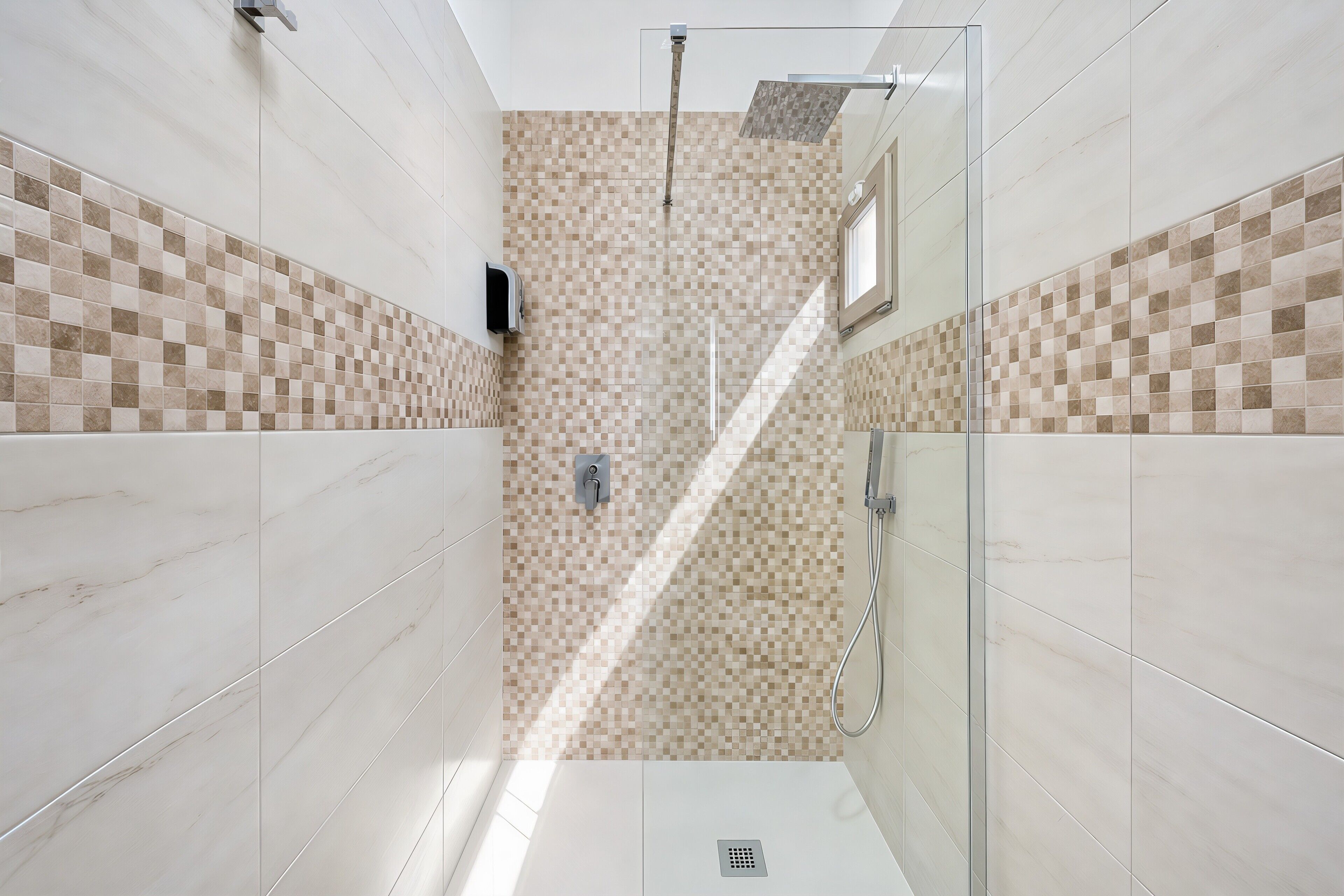 A modern bathroom with a shower, tiled walls, and a glass door.