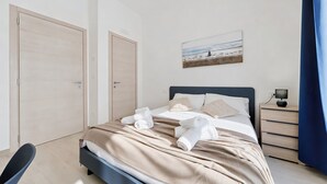 A modern bedroom with a bed, bedside table, and a painting on the wall. - ‘Domus Dell’Angelo 4’ – Comfort and Authenticity in the Heart of Monte Sant’Angelo (Monte Sant'Angelo)