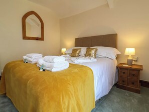 Ein Hotelzimmer mit einem Bett, einem Nachttisch, einer Lampe und einem Spiegel.