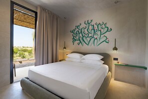 Quarto com cama, vista para o exterior, painel decorativo na parede e mesa de cabeceira com luminária.