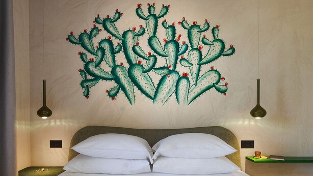 Ein Bett mit weißen Leinen, einem Kopfteil und zwei Nachttischlampen.