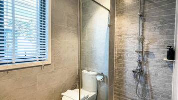 Separate tub and shower, hair dryer, slippers, towels