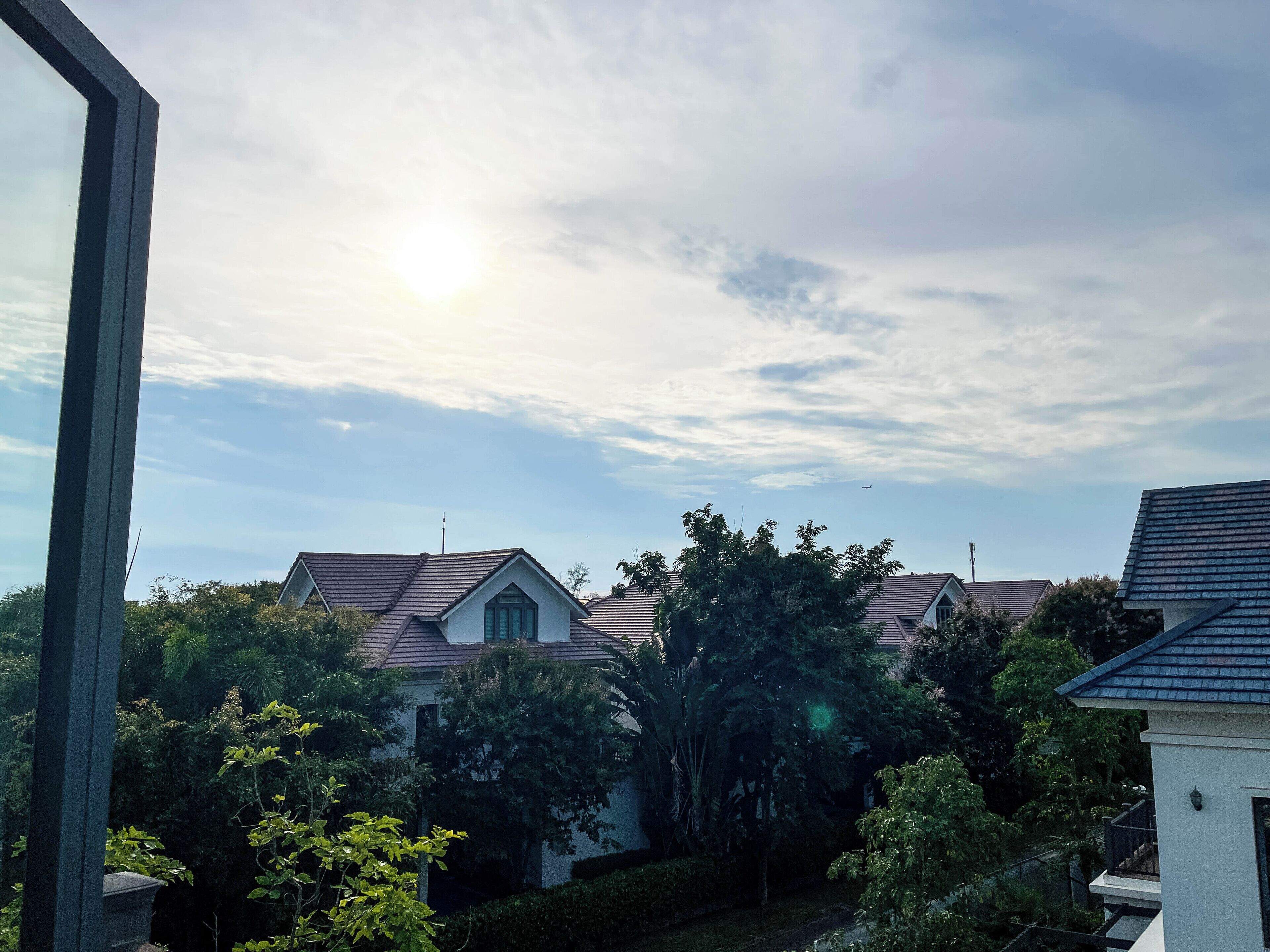 A residential area with houses, trees, and a clear sky.