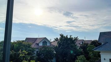A residential area with houses, trees, and a clear sky.