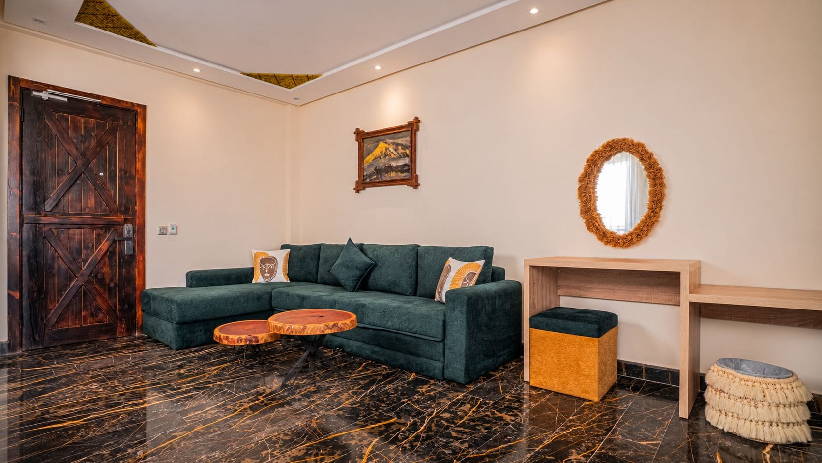 A modern living room with a dark wood door, a green sofa set, a wooden coffee table, and a marble floor.