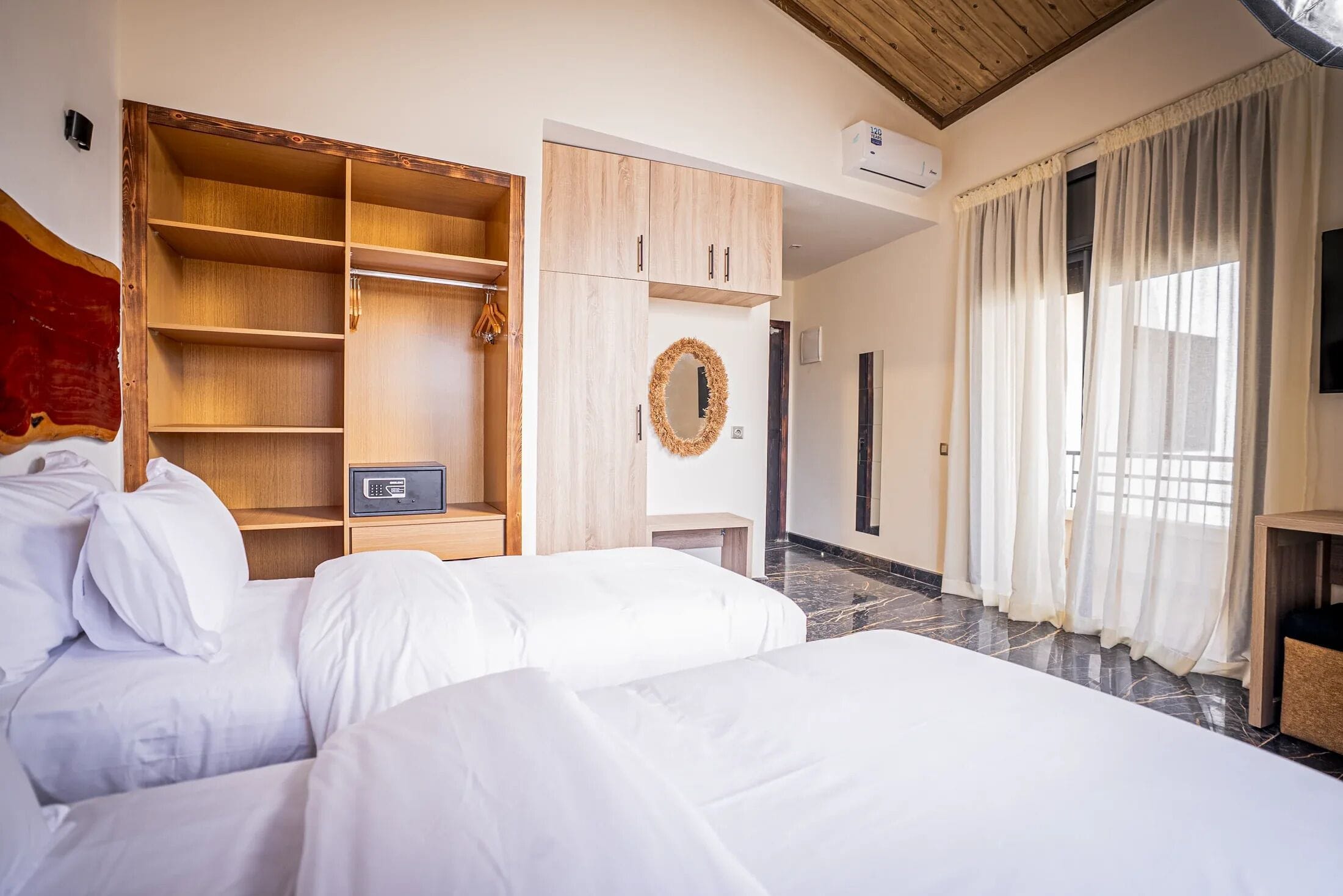 A hotel room with a bed, a wardrobe, a mirror, and a television.