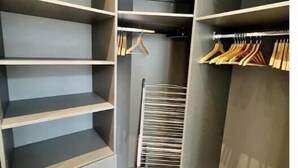 A walk-in closet with multiple shelves, hanging space, and a shoe rack. - Very bright, recently renovated apartment with air conditioning (Île-de-France)
