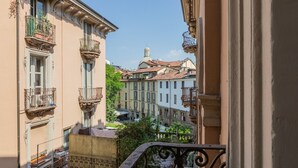Uma varanda com grades de ferro forjado com vista para uma rua com prédios.
