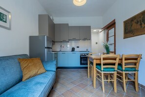 A compact living space with a kitchenette, a dining area, and a sofa. - Finestra sulle Porte Palatine by Wonderful Italy (Turin)