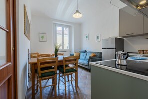 Eine kleine Küche mit Essbereich, einer Couch und einer Kaffeemaschine.