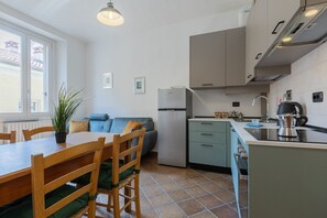 Eine kleine Küche mit Essbereich, einer Couch und einem Fenster.