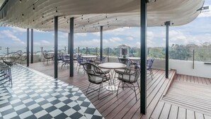 A rooftop terrace with outdoor seating, a checkered floor, and a view of the cityscape. - One Rosebank Apartment- Studio (Johannesburg)