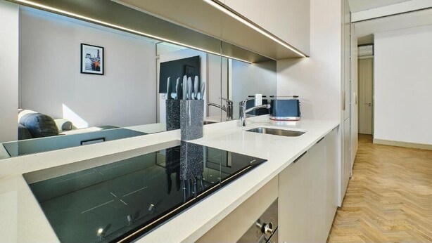 A modern kitchen with a built-in stove, a sink, and a countertop. - One Rosebank Apartment- Studio (Johannesburg)