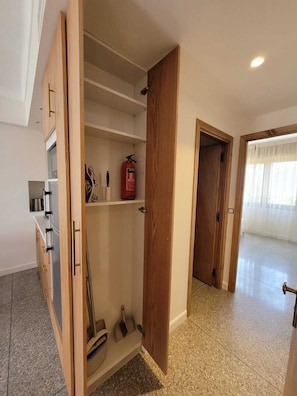 Eine moderne Küche mit Holzschränken, einem eingebauten Ofen und einem Feuerlöscher auf der Arbeitsfläche.