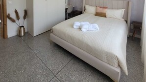 Una camera da letto con un letto, un armadio, una scrivania e un lampadario.