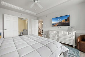 Ett hotellrum med en stor säng, en tv som är monterad på väggen och utsikt över stadsbilden.