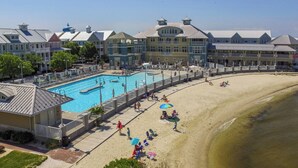Um resort com piscina, praia e vários edifícios com estilos arquitetônicos distintos.