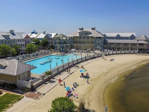 Ein Resort mit Schwimmbad, Strand und mehreren Gebäuden in unterschiedlichem Baustil.