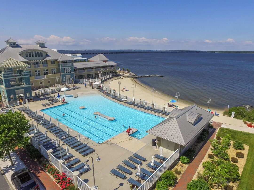 A hotel with a large pool, beach access, and a view of the water.