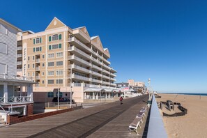 A beachfront hotel with multiple balconies, a boardwalk, and beach chairs. - South Beach is a luxurious building overlooking the boardwalk, beach and ocean. (Ocean City)