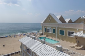 Ein Hotel mit Pool und Blick auf einen Strand.