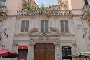 A building with ornate architectural details, a wooden door, and a sign for a bistro. - Finestra Sulle Porte Palatine by Wonderful Italy (Turin)