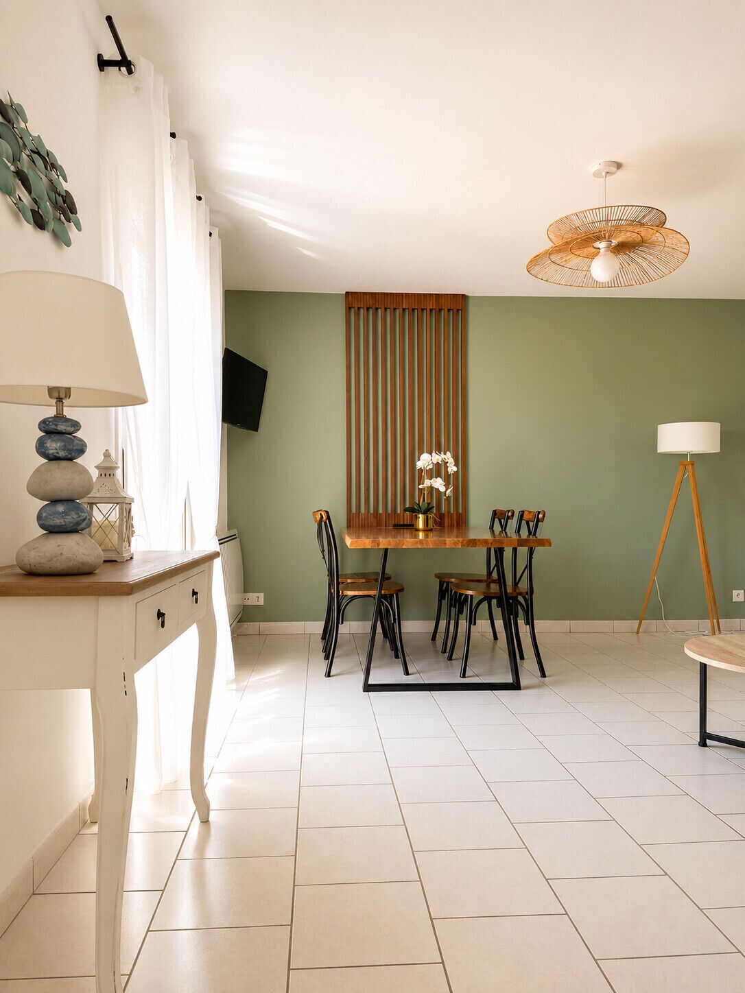 A dining area with a table and chairs, a lamp, and a ceiling fan.