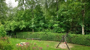 A garden with a swing set, a bench, and a picnic table. - Apartment Hauzenberg with Indoor & Outdoor Pool, Sauna, Lake View (Hauzenberg)
