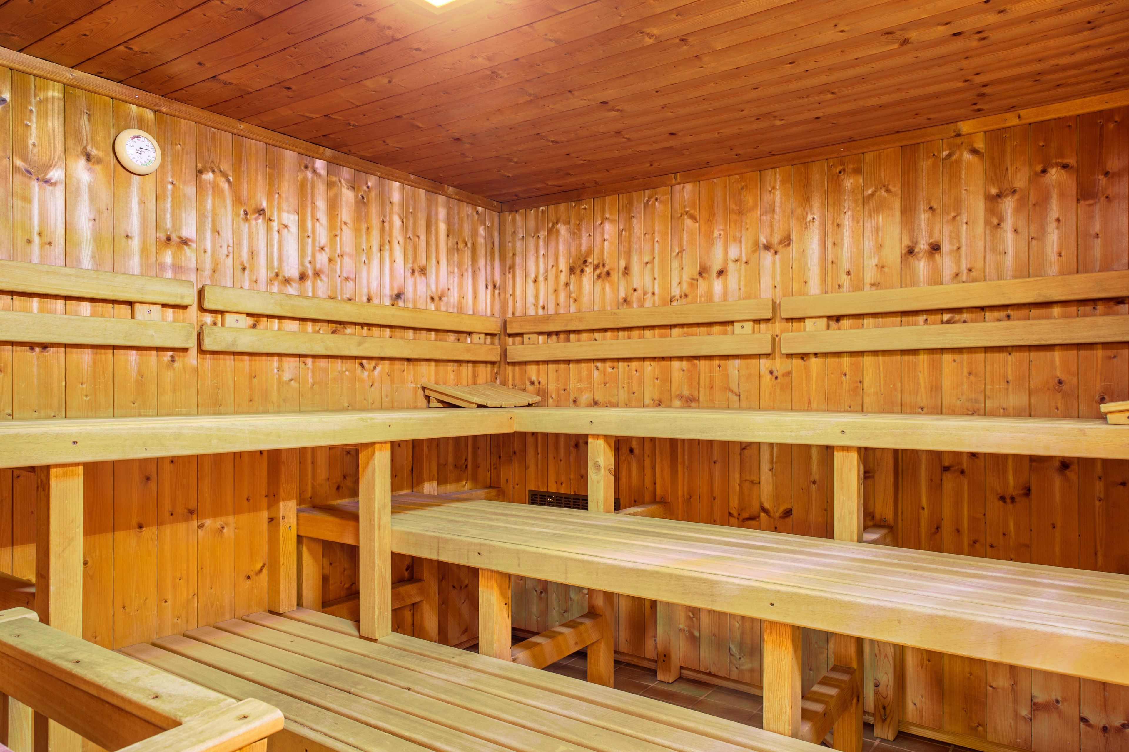 A sauna room with wooden benches and a wooden ceiling.