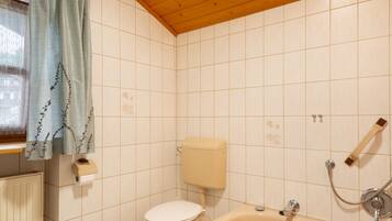 A bathroom with a toilet, a bathtub, and a shower.