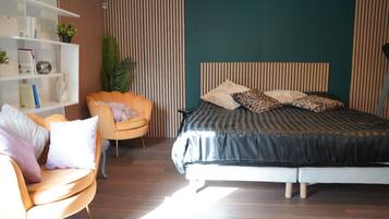 Een slaapkamer met een bed, een stoel, een boekenkast en een potplant.