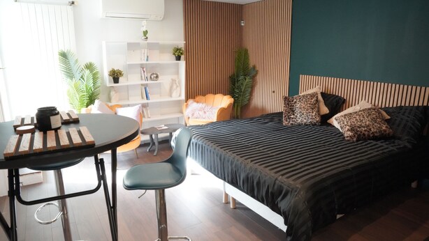 Quarto moderno com cama, escrivaninha, cadeira e estante.