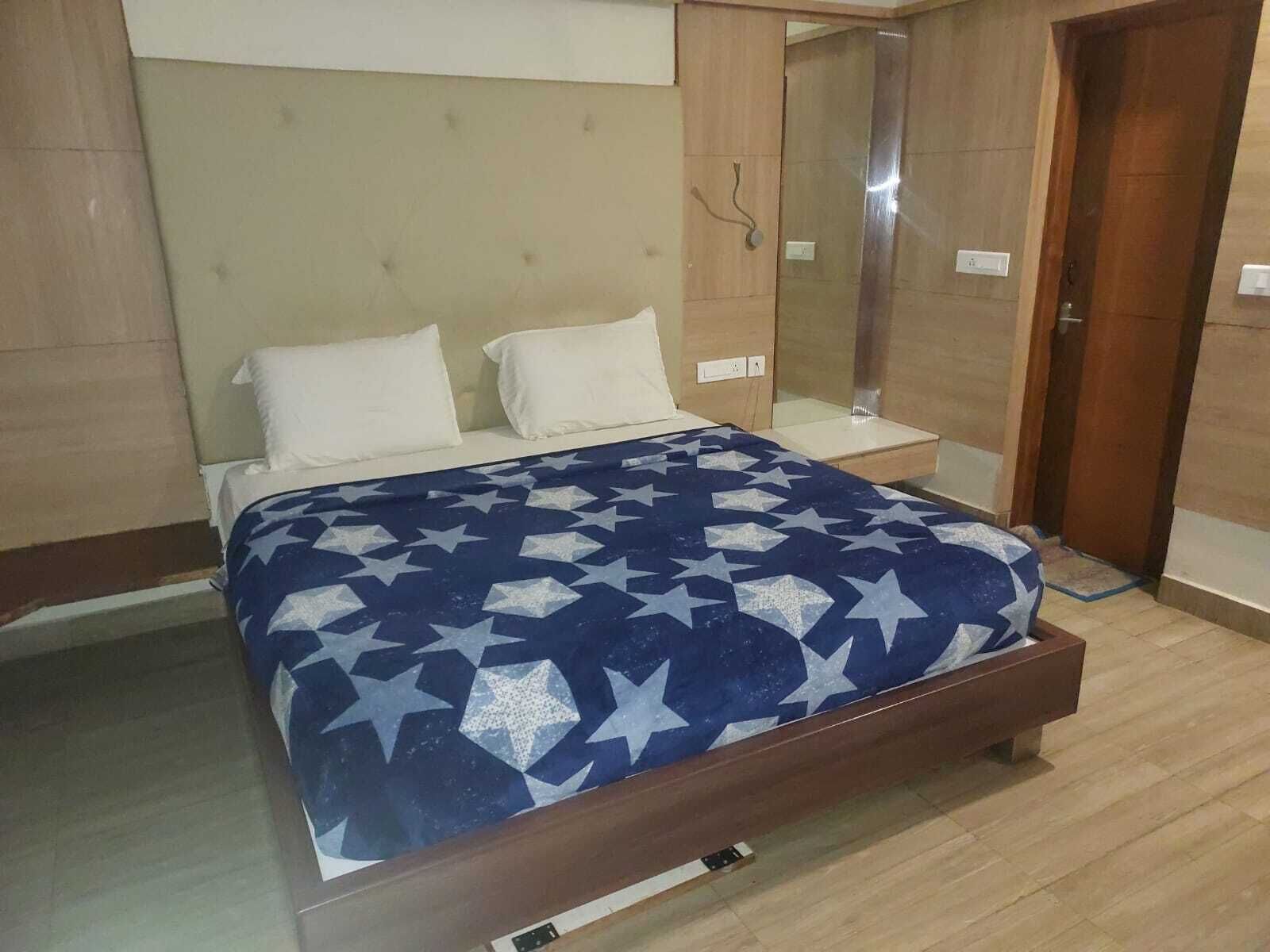 Un dormitori amb llit, una taula de nit i un armari.