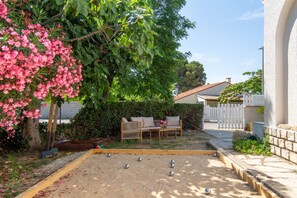 A garden with a sandbox, a wooden bench, and a white fence. - Frontignan, Villa Azzura, swimming pool (Frontignan)