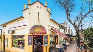 En byggnad med nummer 1907, ett kafé och uteservering.
