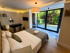 Une chambre à coucher moderne, équipée d’un lit, d’un bureau et d’une télévision.
