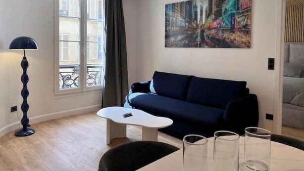 Una sala de estar moderna con un sofá, una mesita de centro y un cuadro en la pared.