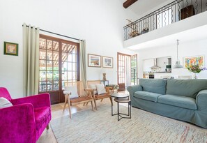 A spacious living room with a sofa, chairs, a dining table, and a balcony with a railing. - Villa Parete Vidauban | Luxury villa with pool and large garden (Vidauban)