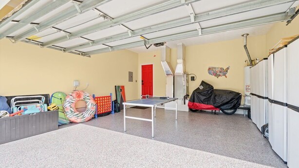Eine Garage mit Tischtennisplatte, einer roten Tür und einem überdachten Fahrzeug.