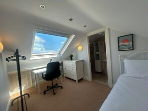 A bedroom with a bed, a desk, a chair, a window, and a door leading to another room. - Elegant 4BDR 4BA Luxury Home Heart of Rathmines (Dublin)