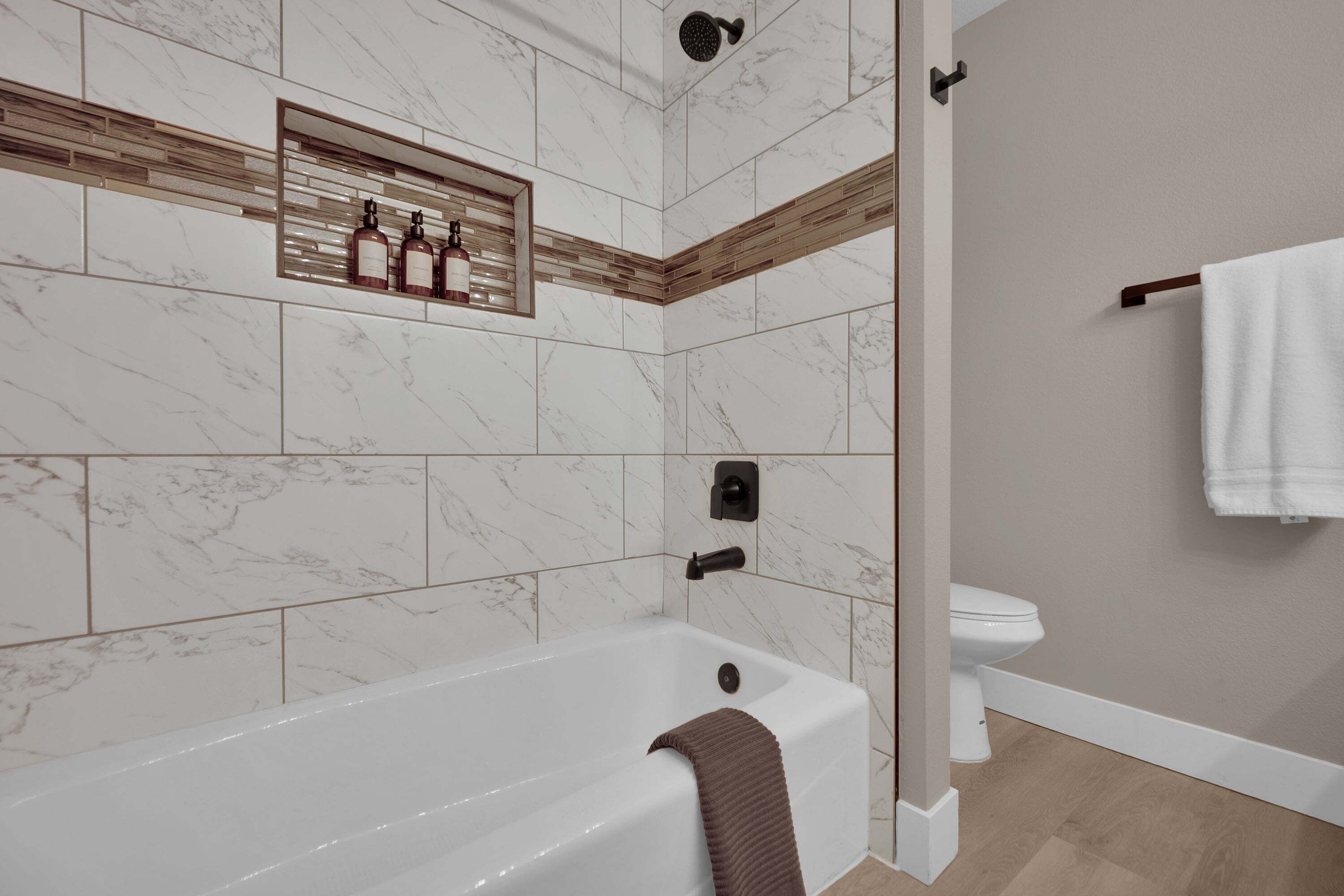 Ein modernes Badezimmer mit einer Badewanne, einer Dusche und einem WC.