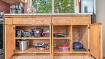 A kitchen with wooden cabinets, a built-in oven, and various kitchen appliances.