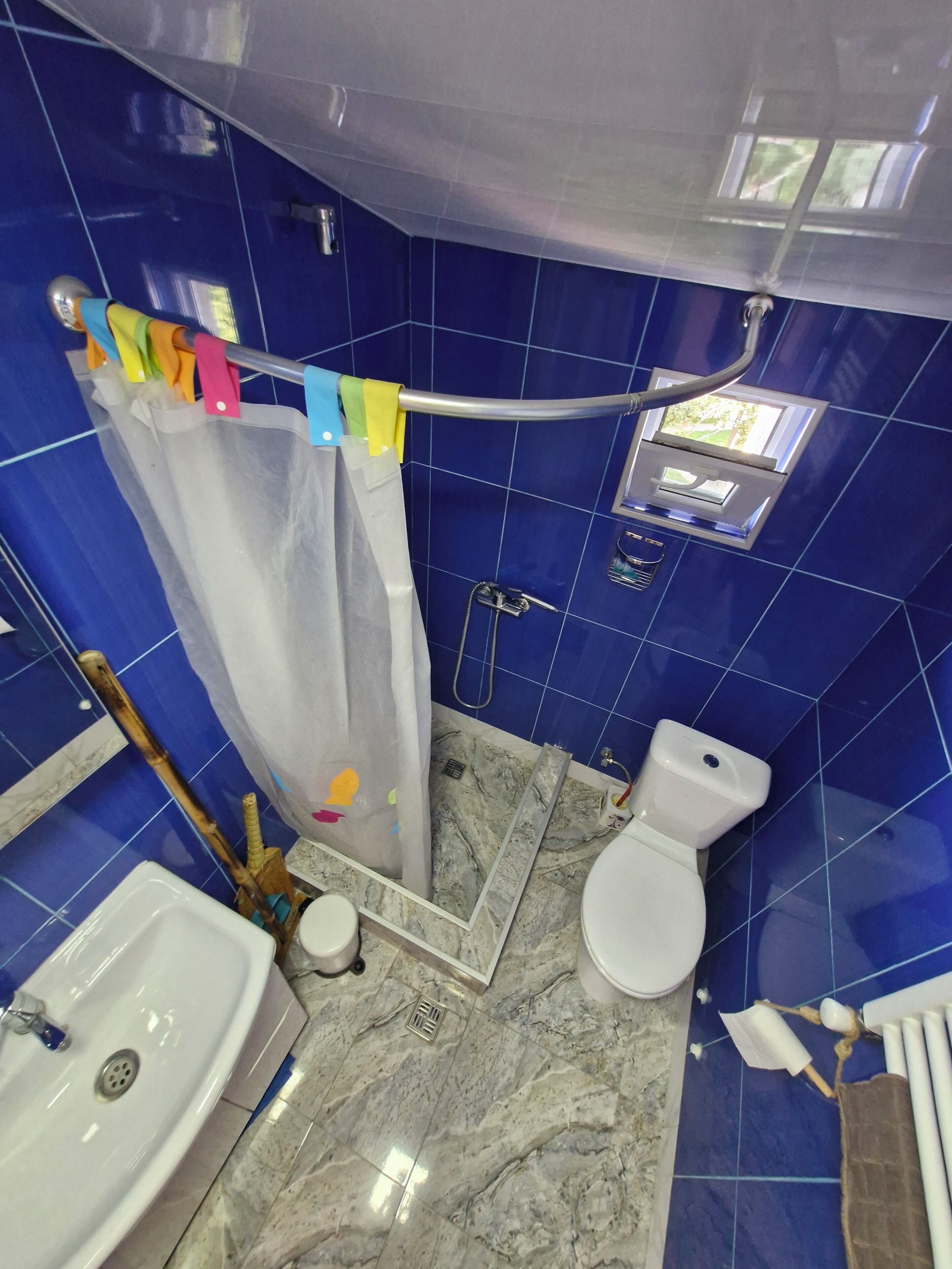 Un baño con ducha, inodoro y lavabo.