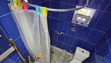 Un baño con ducha, inodoro y lavabo.