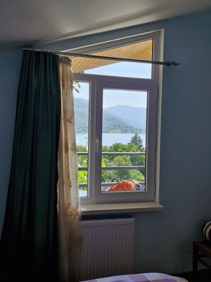 A room with a window overlooking a mountainous landscape.