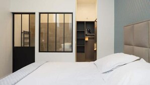 Ein Hotelzimmer mit Bett, Schrank, eingebautem Regal und Fenster.