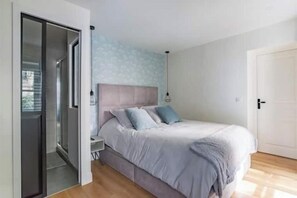 A bedroom with a bed, a nightstand, a wardrobe, and a door leading to another room. - Renovated apartment between the Opera and the Louvre (Île-de-France)