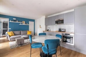A modern kitchen with grey cabinets, a built-in oven, and a microwave. - Renovated apartment between the Opera and the Louvre (Île-de-France)