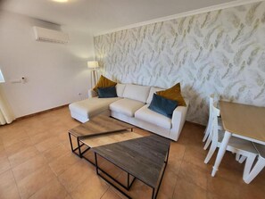 A living room with a sofa, a coffee table, and a dining table with chairs. - El Rincon 12 - One Bed (Los Cristianos)